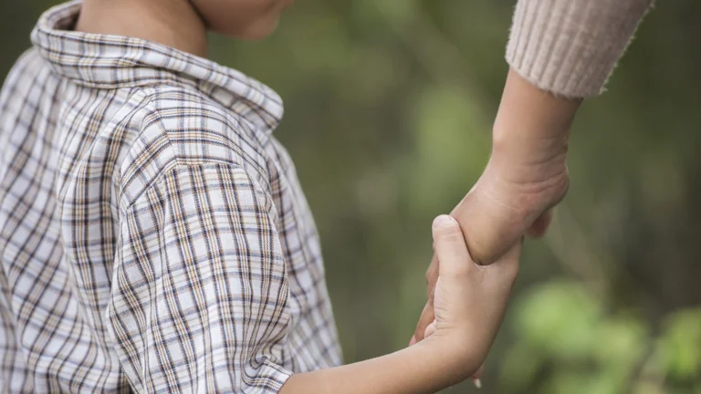 Child holding hand as child support is taken from jackpots