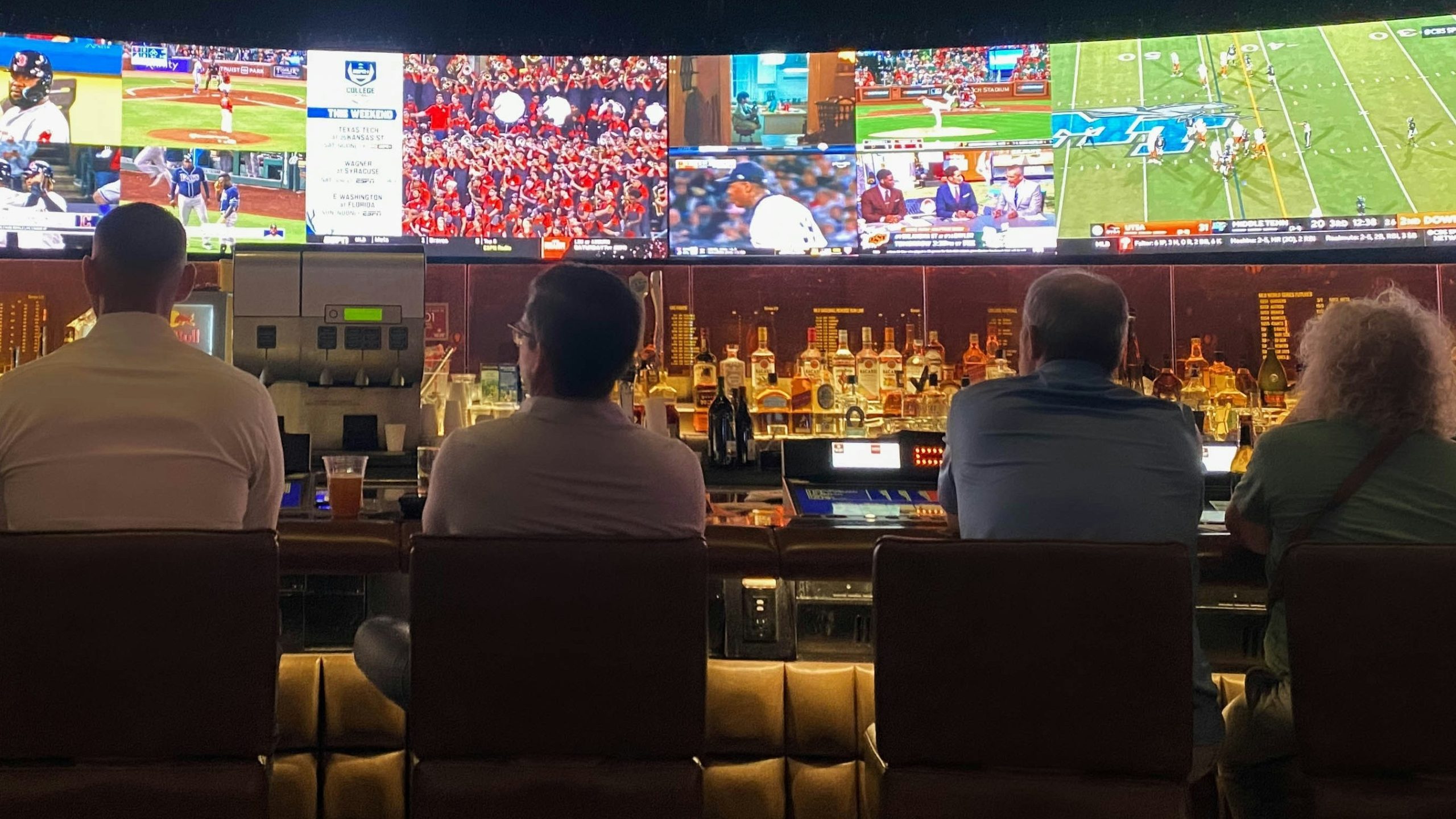 Row of people watching sports amid sports wagering boost